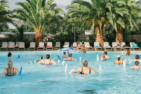 Aquafitness-klasse ved Camping Village Les Mouettes-bassin med personer, der bruger poolnudler.
