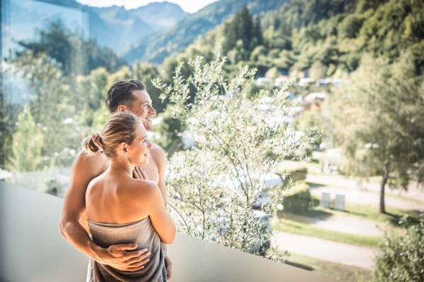 Pareja en el balcón del Alpencamping Nenzing con vista a las montañas
