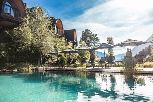 Piscina con tumbonas y sombrillas en el camping Alpencamping Nenzing.