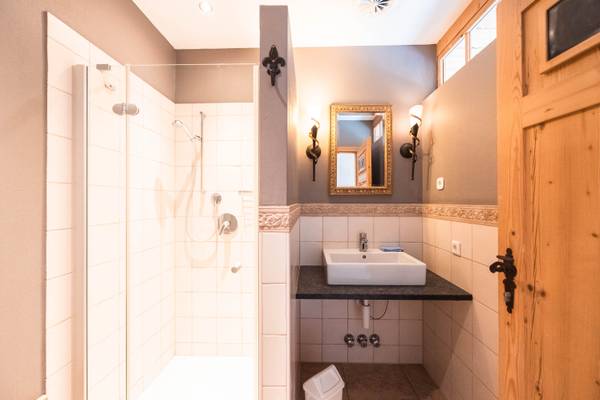 Baño en el Alpencamping Nenzing con ducha, lavabo y espejo.
