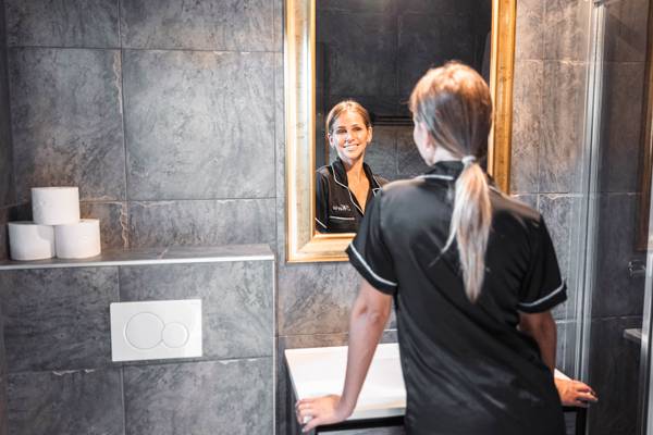 Mujer en el espejo del baño en Alpencamping Nenzing
