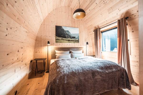 Vista interior de un acogedor dormitorio en Alpencamping Nenzing con paredes de madera y una cama.