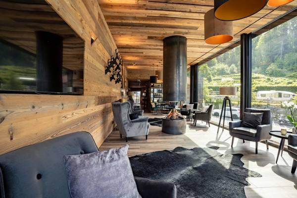 Vista interior del restaurante del Alpencamping Nenzing con paredes de madera y muebles modernos.