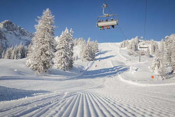 Telesilla en una estación de esquí cubierta de nieve con esquiadores en las pistas