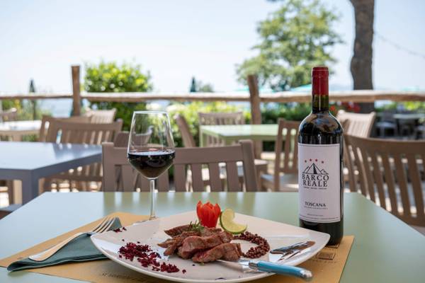 Tisch mit Steak, Wein und Getränk auf dem Campingplatz Barco Reale.