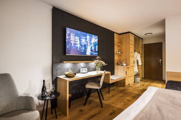 Innenansicht einer Suite im Camping Wirthshof mit Schreibtisch, Stuhl und Fernseher.