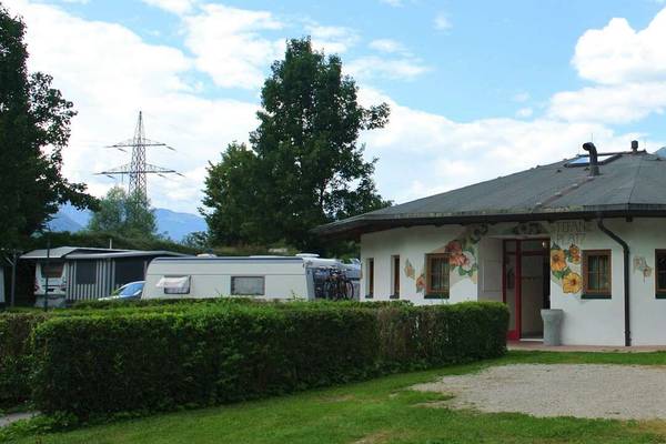 Experience Resort Aufenfeld campsite building with flower murals and bicycles.