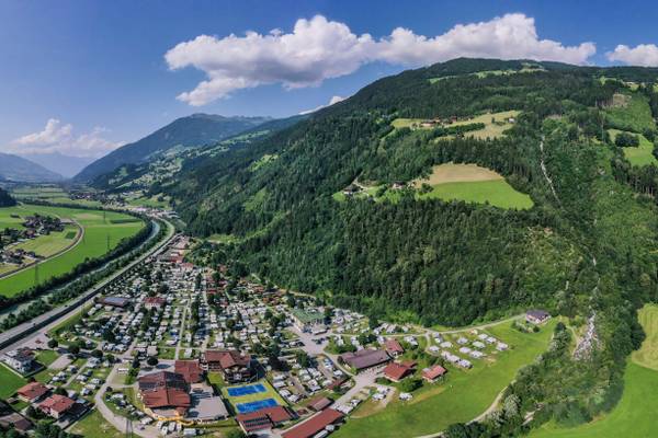Aerial view of Erlebnis Resort Aufenfeld campsite with many tents and buildings.