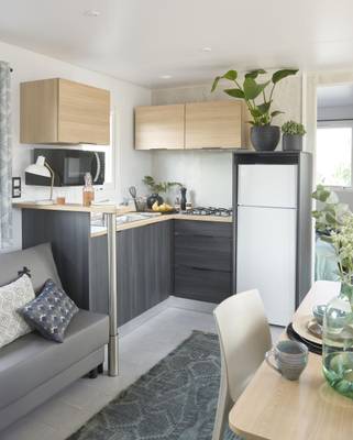 Interieur van een camper op Europacamping Nommerlayen, met keuken, magnetron, koelkast en eethoek.
