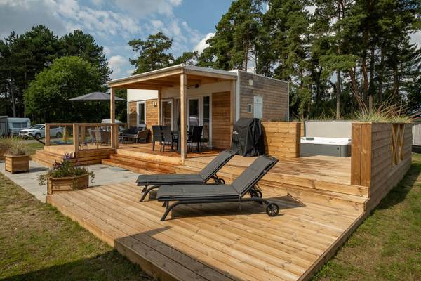 Campamento Feddet Strand Resort con una cabaña y una terraza de madera.