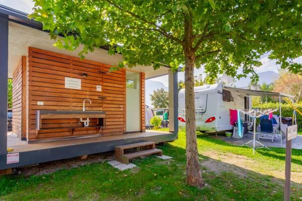 Campingplads med privat badeværelse under træet, håndvask og tørrestativ