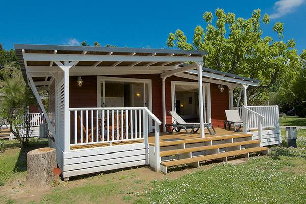 Campamento Nature Parc L`Ardéchois con un pequeño chalet rojo y blanco