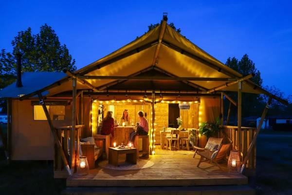 Serata al campeggio Papillon Country Resort con persone sedute sulla veranda.