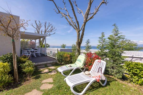 Campingterrasse med liggestole og havudsigt