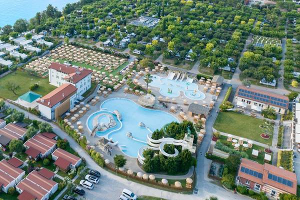 Luftfoto af campingpladsen Piani di Clodia med swimmingpools og hav i baggrunden.