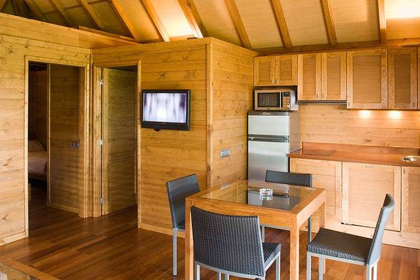 Indre udsigt af et campingresort, køkken og seng synlig.