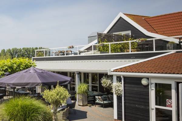 Außenbereich des Campingplatzes Strandpark De Zeeuwse Kust mit Pavillons, Tischen und Stühlen.