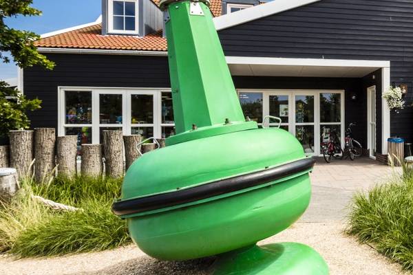 Eingang des Campingplatzes Strandpark De Zeeuwse Kust mit einer grünen Boje als Skulptur.