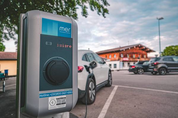 Estación de carga para autos eléctricos con auto cargando en el estacionamiento del camping