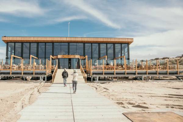 Strandpark De Zeeuwse Kust Gebäude mit Glaswänden und Holzdeck.