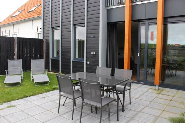 Terrasse mit Tisch und Stühlen vor einem Haus