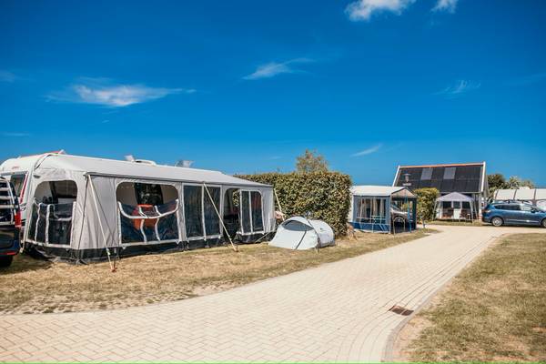 Campingplatz mit Zelten unter blauem Himmel am Strandpark De Zeeuwse Kust.
