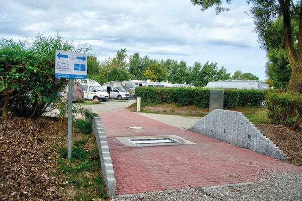 Einfahrtsweg zum Campingplatz Wulfener Hals mit roten Ziegeln und Hinweisschildern