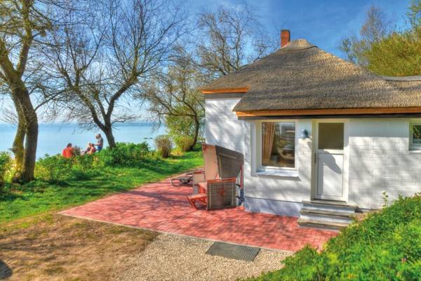 Ein kleines weißes Strandhaus mit Strohdach im Campingplatz Wulfener Hals.