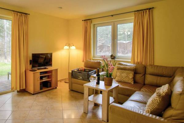 Living room of Camping- und Ferienpark Havelberge with large windows and a couch.