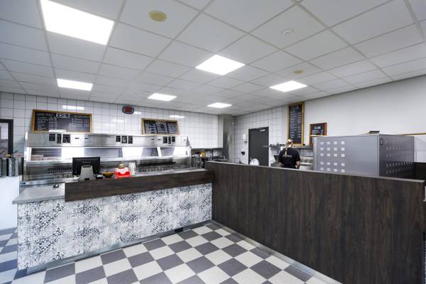 Innenansicht des Restaurants im Camping De Paal mit kariertem Boden und gefliesten Wänden.