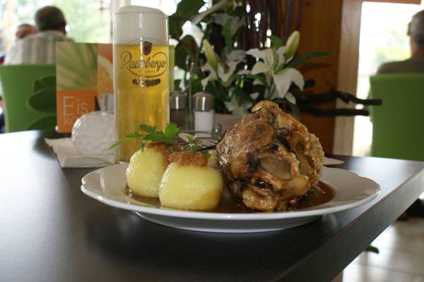 Ein Gericht mit Fleisch, Kartoffeln und Soße auf einem Teller mit einem Glas Bier im LuxOase Freizeitpark.