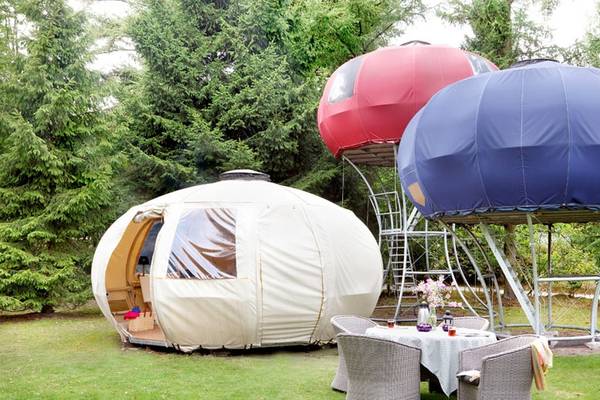 Kampeerterrein Camping De Wildhoeve met drie ongewone tenten in verschillende kleuren.