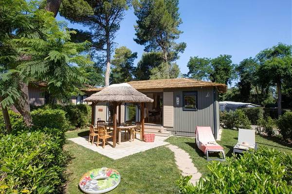 Camping Village Le Brasilia hébergement de vacances avec un gazebo et des chaises longues.