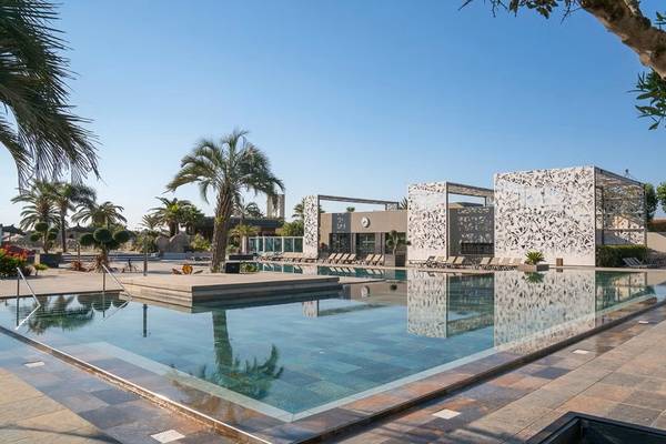 Piscine extérieure avec chaises longues et structures décoratives au Camping Village Le Brasilia.