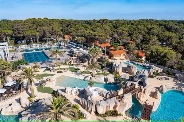 Vue aérienne du Camping Village Le Brasilia avec des piscines et un paysage rocheux.