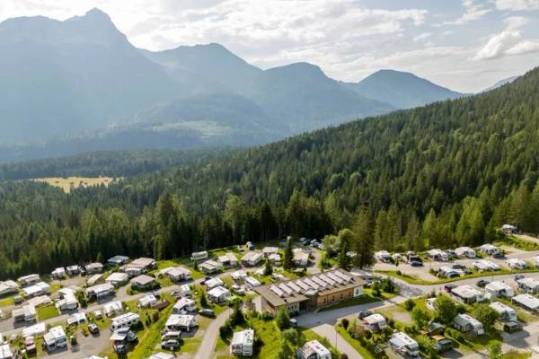 Luftaufnahme des Zugspitz Resort Campingplatzes mit Bergen im Hintergrund.