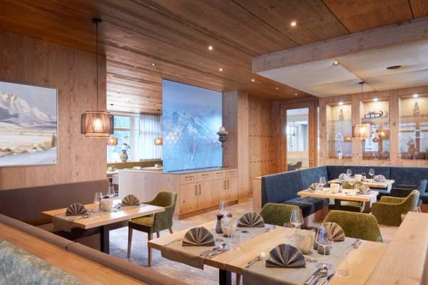 Zugspitz Resort Camping, Innenraum des Restaurants mit Holzwänden und gedeckten Tischen.