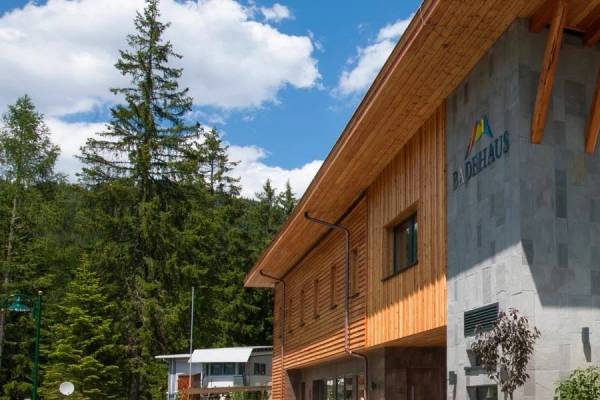Zugspitz Resort Campinggebäude mit Holzfassade und Steinwänden, umgeben von Bäumen.