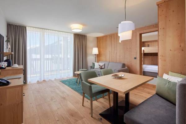 Innenbereich des Zugspitz Resorts mit Holzwänden und modernem Wohnzimmer-Setup.