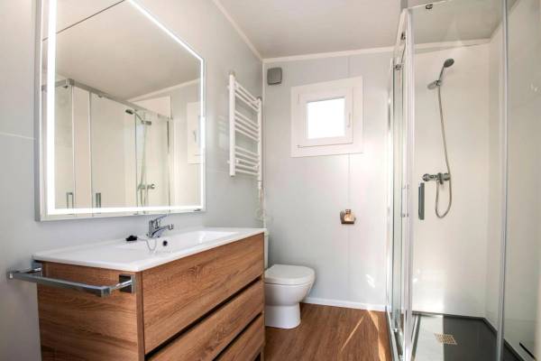 Salle de bain au La Marina Camping & Resort avec lavabo, miroir, toilettes et douche.
