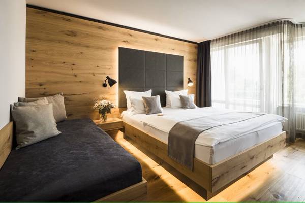 Schlafzimmer im Camping Wirthshof mit Holzwänden und Doppelbett.