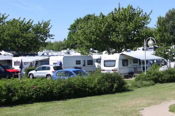 Ostseecamping Heide Campingplatz mit vielen Wohnmobilen und Autos geparkt.