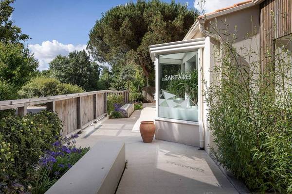 Espace extérieur du camping Le Pin Parasol avec une porte en verre et un pont en bois.