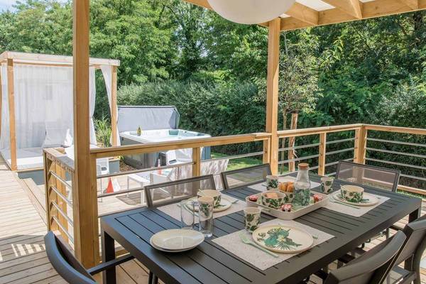 Terrasse avec jacuzzi et table au Camping Le Pin Parasol