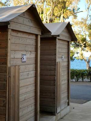Zwei Holzduschen mit S1 und S2 Schildern am Campingplatz Les Criques de Porteils.