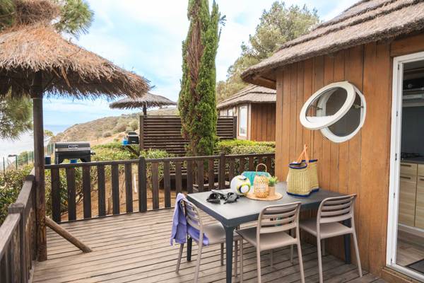 Terrasse mit Tisch und Sonnenschirm im Camping Les Criques de Porteils