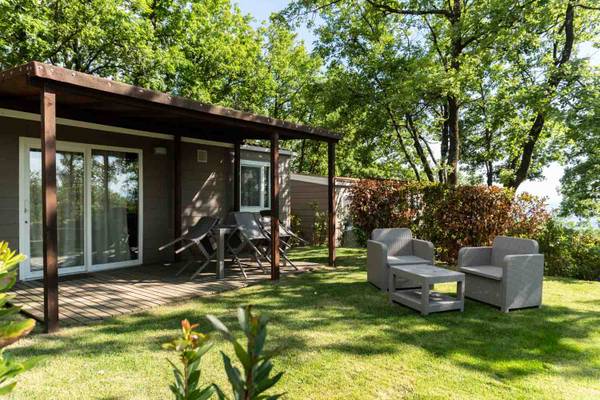 Campingplatz Barco Reale Ferienhaus mit Gartenmöbeln an einem sonnigen Tag.