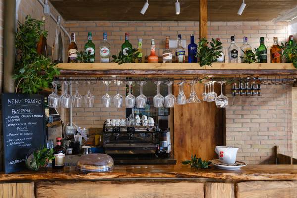 Eine Bar mit Weingläsern und Cocktails auf dem Regal.