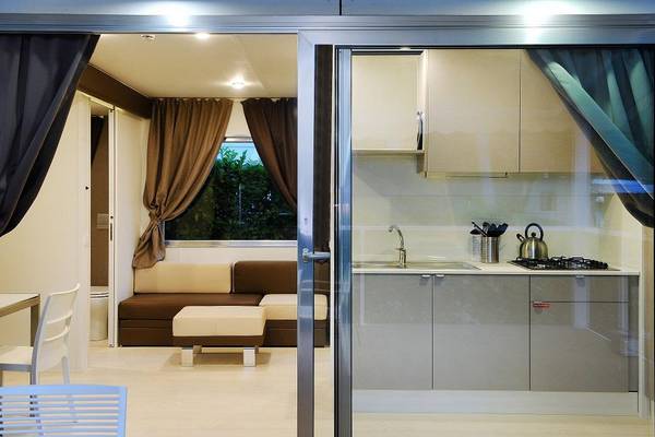 Interior view of campsite accommodation with sofa and kitchen