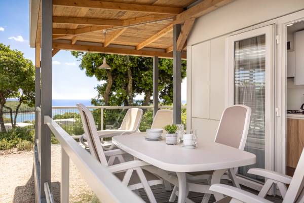 Terrasse du Camping Vestar avec table et chaises donnant sur l'océan